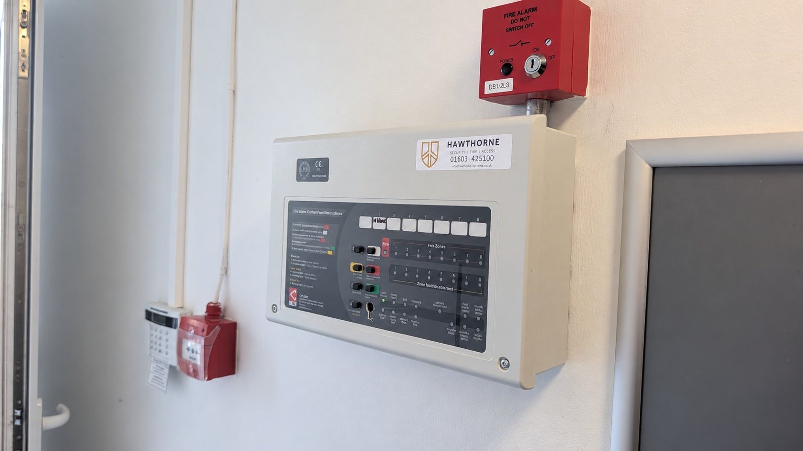 C-Tec fire alarm control panel with a Hawthorne service label, isolator and call point