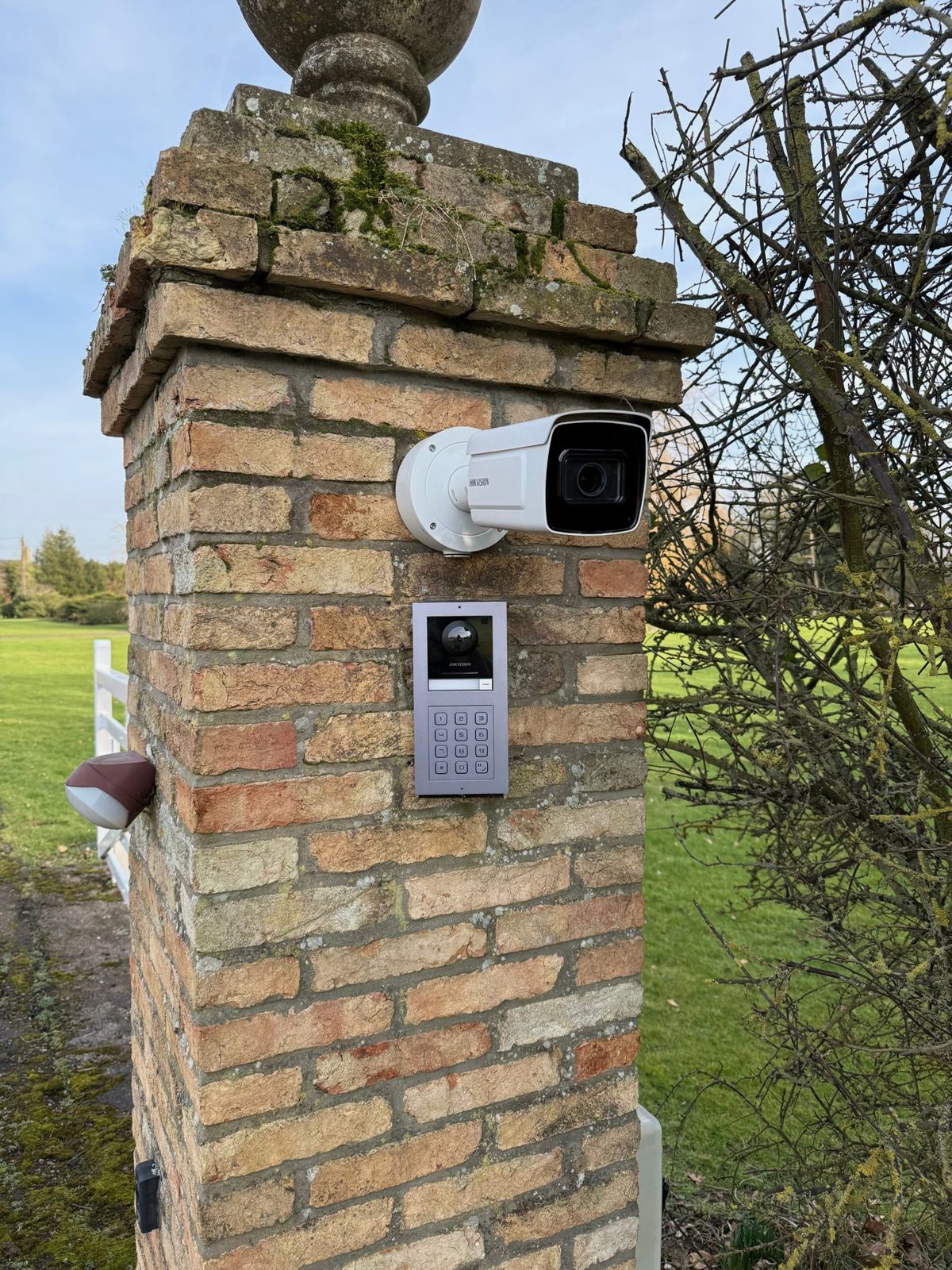 CCTV camera and video intercom fitted to a brick gate pillar